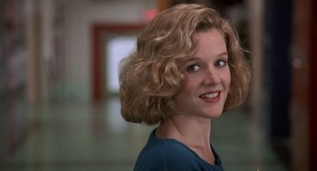 Movie still from “Kindergarten Cop” (1990), directed by Ivan Reitman – A woman with blonde curly hair smiling for the camera; Close Up shot, Low angle