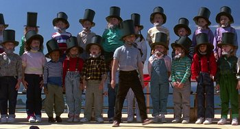 Movie still from “Kindergarten Cop” (1990), directed by Ivan Reitman – A group of children wearing top hats posing for a picture; Wide shot, High angle