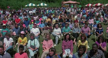 Movie still from “Kindergarten Cop” (1990), directed by Ivan Reitman – A large group of people sitting on lawn chairs; Wide shot, High angle