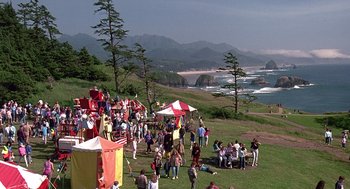 Movie still from “Kindergarten Cop” (1990), directed by Ivan Reitman – A group of people standing on top of a grass covered field; Extreme Wide shot, High angle