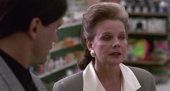 Movie still from “Kindergarten Cop” (1990), directed by Ivan Reitman – An older woman talking to a young man in a store; Close Up shot, Low angle