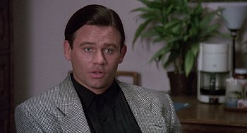Movie still from “Kindergarten Cop” (1990), directed by Ivan Reitman – A person wearing a suit and tie; Close Up shot, Over the shoulder angle