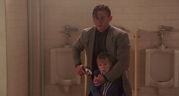 Movie still from “Kindergarten Cop” (1990), directed by Ivan Reitman – A man and a child in a bathroom; Medium shot, Over the shoulder angle