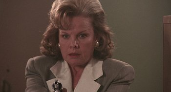 Movie still from “Kindergarten Cop” (1990), directed by Ivan Reitman – An older woman is holding a gun in her hand; Close Up shot, Low angle