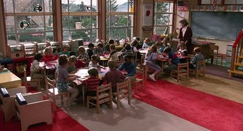 Movie still from “Kindergarten Cop” (1990), directed by Ivan Reitman – A group of children sitting at tables in a room; Wide shot, High angle