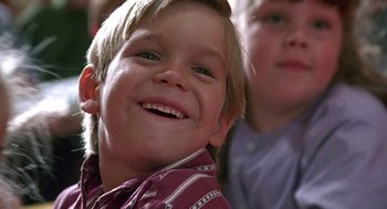 Movie still from “Kindergarten Cop” (1990), directed by Ivan Reitman – A child smiling at the camera; Close Up shot, Low angle
