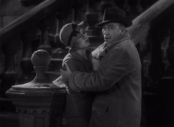 Movie still from “King Kong” (1933), directed by Merian C. Cooper – An older man and a younger woman hugging; Medium shot, High angle