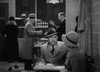 Movie still from “King Kong” (1933), directed by Merian C. Cooper – A black and white photo of a man and a woman; Medium shot, High angle