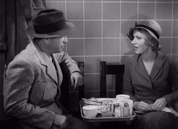 Movie still from “King Kong” (1933), directed by Merian C. Cooper – A man and a woman sitting at a table; Medium shot, High angle