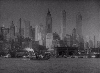 Movie still from “King Kong” (1933), directed by Merian C. Cooper – An old photo of a city with a boat in the water; Extreme Wide shot, High angle