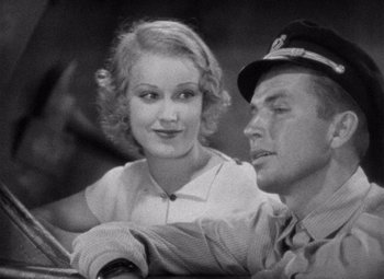 Movie still from “King Kong” (1933), directed by Merian C. Cooper – An old photo of a man and a woman sitting next to each other; Close Up shot, High angle