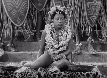 Movie still from “King Kong” (1933), directed by Merian C. Cooper – A black and white photo of a woman sitting on the ground; Medium shot, High angle