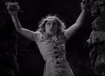 Movie still from “King Kong” (1933), directed by Merian C. Cooper – A black - and - white photo of a woman holding her arms up; Medium shot, Low angle
