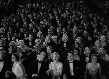Movie still from “King Kong” (1933), directed by Merian C. Cooper – A group of people sitting in front of each other; Extreme Wide shot, High angle