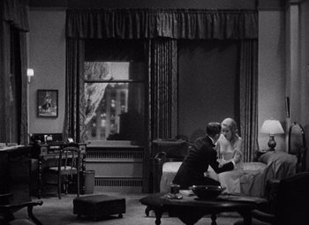 Movie still from “King Kong” (1933), directed by Merian C. Cooper – A black and white photo of a man and a woman in a living room; Wide shot, High angle