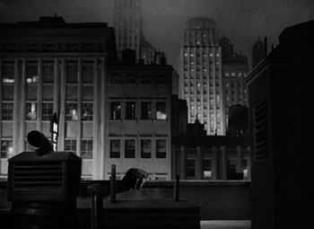 Movie still from “King Kong” (1933), directed by Merian C. Cooper – A black - and - white photo of a city at night; Extreme Wide shot, High angle