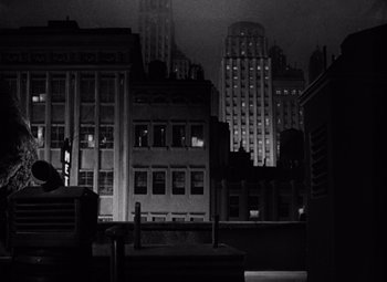 Movie still from “King Kong” (1933), directed by Merian C. Cooper – A black - and - white photo of a city at night; Extreme Wide shot, High angle