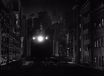 Movie still from “King Kong” (1933), directed by Merian C. Cooper – A black and white photo of a train on the tracks at night; Extreme Wide shot, Low angle