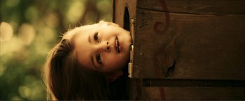 Movie still from “Kiss Kiss Bang Bang” (2005), directed by Shane Black – A little girl is peeking out of a wooden box; Close Up shot, High angle