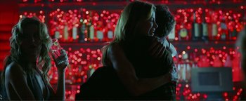 Movie still from “Kiss Kiss Bang Bang” (2005), directed by Shane Black – A man and a woman hugging each other in front of some lights; Medium shot, Over the shoulder angle