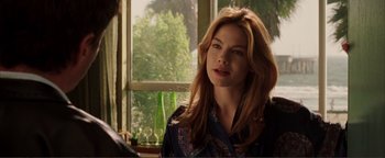 Movie still from “Kiss Kiss Bang Bang” (2005), directed by Shane Black – A beautiful woman with long red hair standing in front of a window; Close Up shot, Over the shoulder angle