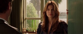 Movie still from “Kiss Kiss Bang Bang” (2005), directed by Shane Black – A woman with long red hair standing in front of a window; Close Up shot, Over the shoulder angle