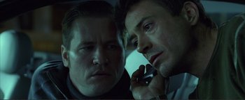 Movie still from “Kiss Kiss Bang Bang” (2005), directed by Shane Black – Two men in the back seat of a car talking on a cell phone; Close Up shot, Low angle