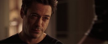Movie still from “Kiss Kiss Bang Bang” (2005), directed by Shane Black – A person wearing a black t - shirt; Close Up shot, Over the shoulder angle