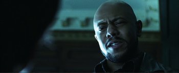 Movie still from “Kiss Kiss Bang Bang” (2005), directed by Shane Black – A man with a bald head is looking at the camera; Close Up shot, Low angle