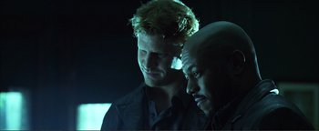 Movie still from “Kiss Kiss Bang Bang” (2005), directed by Shane Black – A man and a bald man standing next to each other in the dark; Close Up shot, Over the shoulder angle