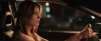 Movie still from “Kiss Kiss Bang Bang” (2005), directed by Shane Black – A woman sitting in the driver's seat of a car at night; Close Up shot, Over the shoulder angle