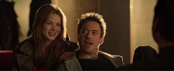 Movie still from “Kiss Kiss Bang Bang” (2005), directed by Shane Black – A man and a woman are smiling for the camera; Close Up shot, Over the shoulder angle
