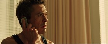 Movie still from “Kiss Kiss Bang Bang” (2005), directed by Shane Black – A person holding a cell phone to his ear; Close Up shot, Over the shoulder angle