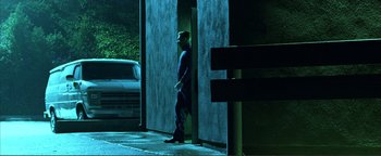 Movie still from “Kiss Kiss Bang Bang” (2005), directed by Shane Black – A man standing next to a wall at night; Wide shot, Low angle