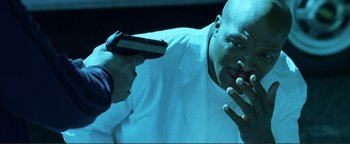 Movie still from “Kiss Kiss Bang Bang” (2005), directed by Shane Black – A man in a white lab coat is holding a gun; Close Up shot, Low angle
