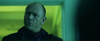 Movie still from “Kiss Kiss Bang Bang” (2005), directed by Shane Black – A man with a bald head is standing in a room; Close Up shot, Low angle