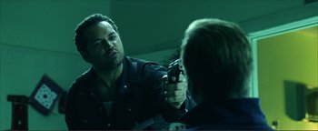 Movie still from “Kiss Kiss Bang Bang” (2005), directed by Shane Black – A man holding a gun in front of a mirror; Close Up shot, Over the shoulder angle