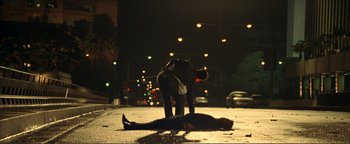 Movie still from “Kiss Kiss Bang Bang” (2005), directed by Shane Black – A person is laying on the ground in the middle of the street; Wide shot, Low angle
