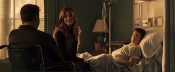 Movie still from “Kiss Kiss Bang Bang” (2005), directed by Shane Black – A woman sitting in a chair in a room; Medium shot, Over the shoulder angle