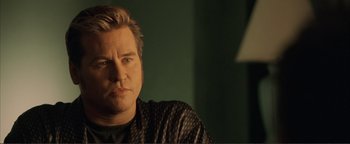 Movie still from “Kiss Kiss Bang Bang” (2005), directed by Shane Black – A person sitting in a room; Close Up shot, Low angle