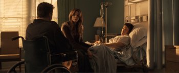 Movie still from “Kiss Kiss Bang Bang” (2005), directed by Shane Black – A woman sitting in a wheel chair next to a man in a hospital bed; Medium shot, Over the shoulder angle