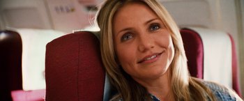 Movie still from “Knight and Day” (2010), directed by James Mangold – A woman sitting in a chair smiling for the camera; Close Up shot, Over the shoulder angle