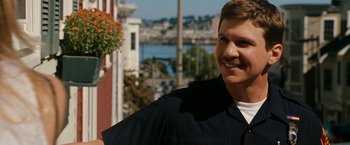 Movie still from “Knight and Day” (2010), directed by James Mangold – A man standing on a sidewalk near a body of water; Close Up shot, Over the shoulder angle