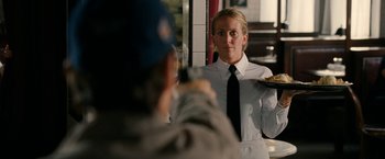 Movie still from “Knight and Day” (2010), directed by James Mangold – A woman holding a tray in front of a mirror; Medium shot, Over the shoulder angle