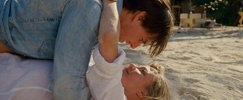 Movie still from “Knight and Day” (2010), directed by James Mangold – A man and a woman playing with each other on the beach; Close Up shot, High angle