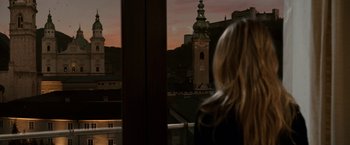 Movie still from “Knight and Day” (2010), directed by James Mangold – A woman looking out of a window at a city skyline; Wide shot, Over the shoulder angle