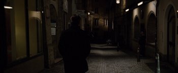 Movie still from “Knight and Day” (2010), directed by James Mangold – A man is walking down the street at night; Wide shot, Over the shoulder angle