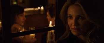 Movie still from “Knight and Day” (2010), directed by James Mangold – A woman sitting in front of a window with a candle in the background; Close Up shot, Over the shoulder angle