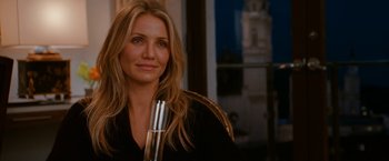 Movie still from “Knight and Day” (2010), directed by James Mangold – A person sitting at a table holding a glass; Close Up shot, Over the shoulder angle