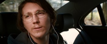 Movie still from “Knight and Day” (2010), directed by James Mangold – A person wearing headphones in a car; Close Up shot, Over the shoulder angle